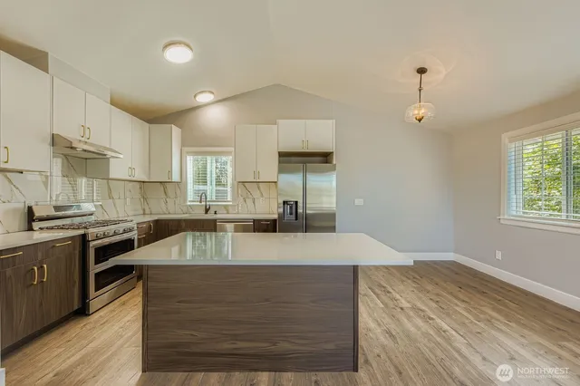 a large kitchen with granite countertop a stove and a sink