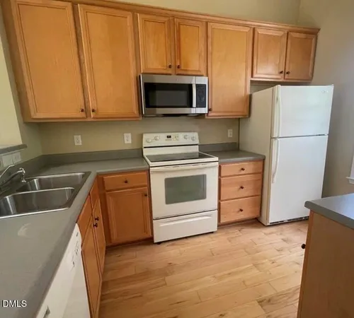 a kitchen with sink a microwave and refrigerator