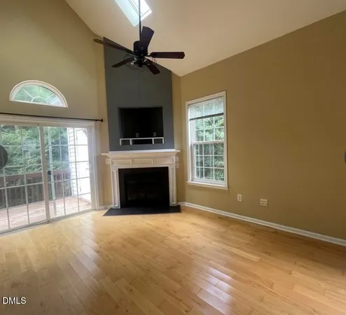 a view of an empty room with a fireplace and a window