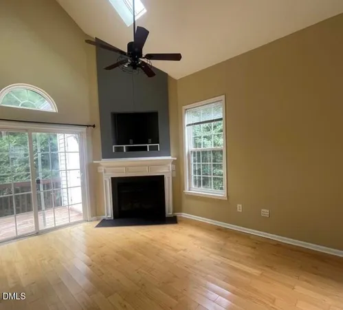 wooden floor fireplace and windows in an empty room