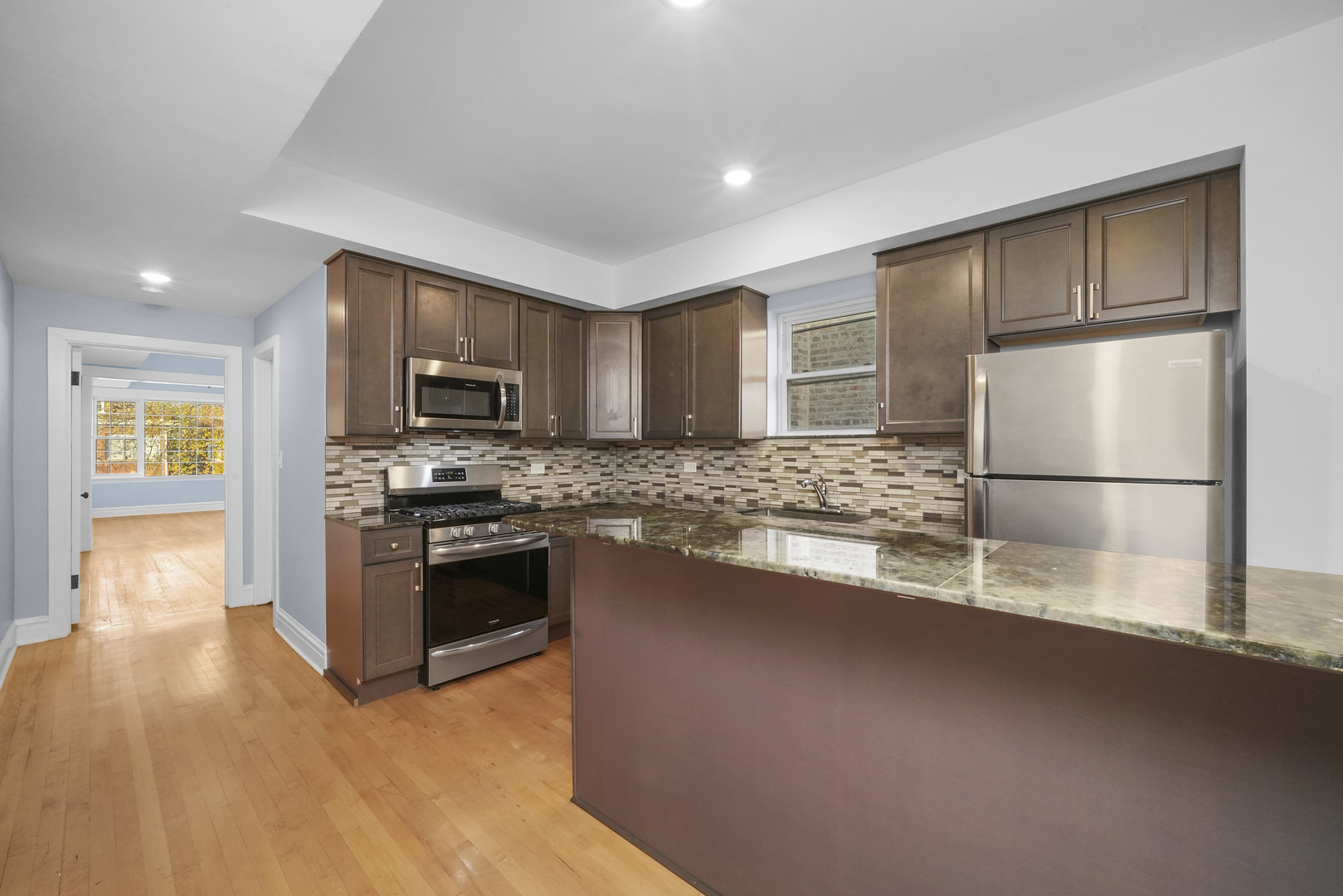 4239 West Melrose Street, Unit 2 Chicago, IL 60641 - Photo 19 of 27 a kitchen with stainless steel appliances granite countertop a refrigerator a stove top oven a sink and dishwasher
