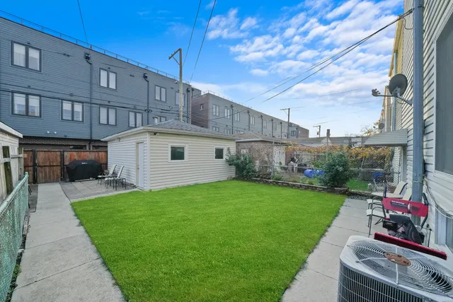 a view of a backyard with plants and wooden fence