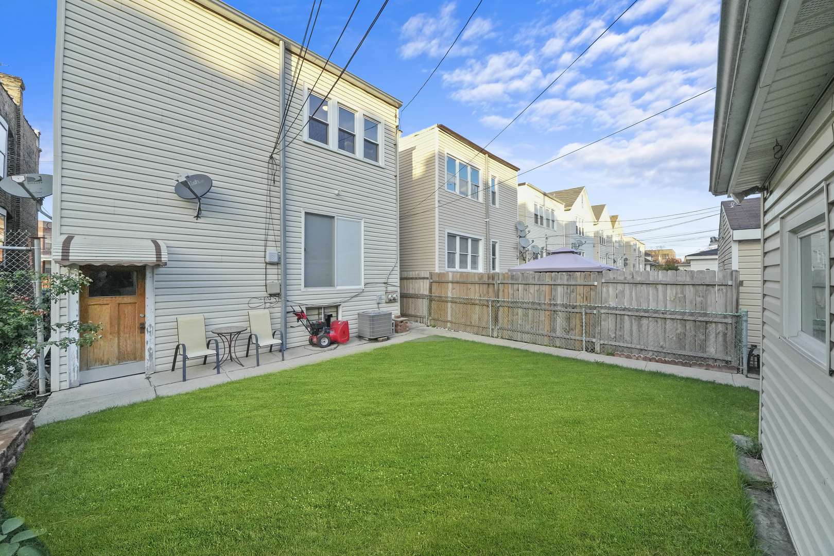 4239 West Melrose Street, Unit 2 Chicago, IL 60641 - Photo 26 of 27 a view of a backyard with plants and wooden fence