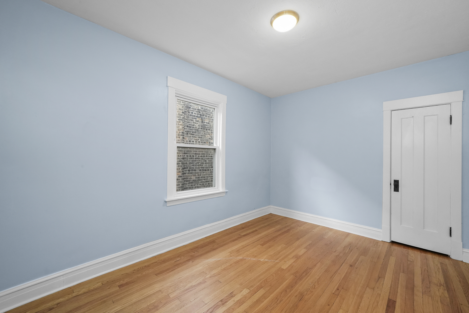 4239 West Melrose Street, Unit 2 Chicago, IL 60641 - Photo 7 of 27 an empty room with wooden floor and windows