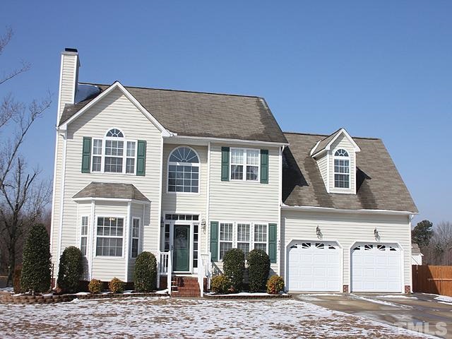 a view of a house with a yard and large tree