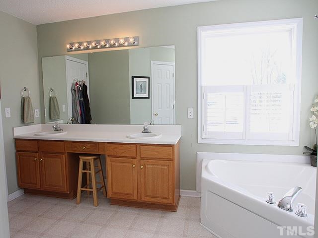 4908 Topstone Road Raleigh, NC 27603 - Photo 8 of 14 a bathroom with a tub a sink and a window