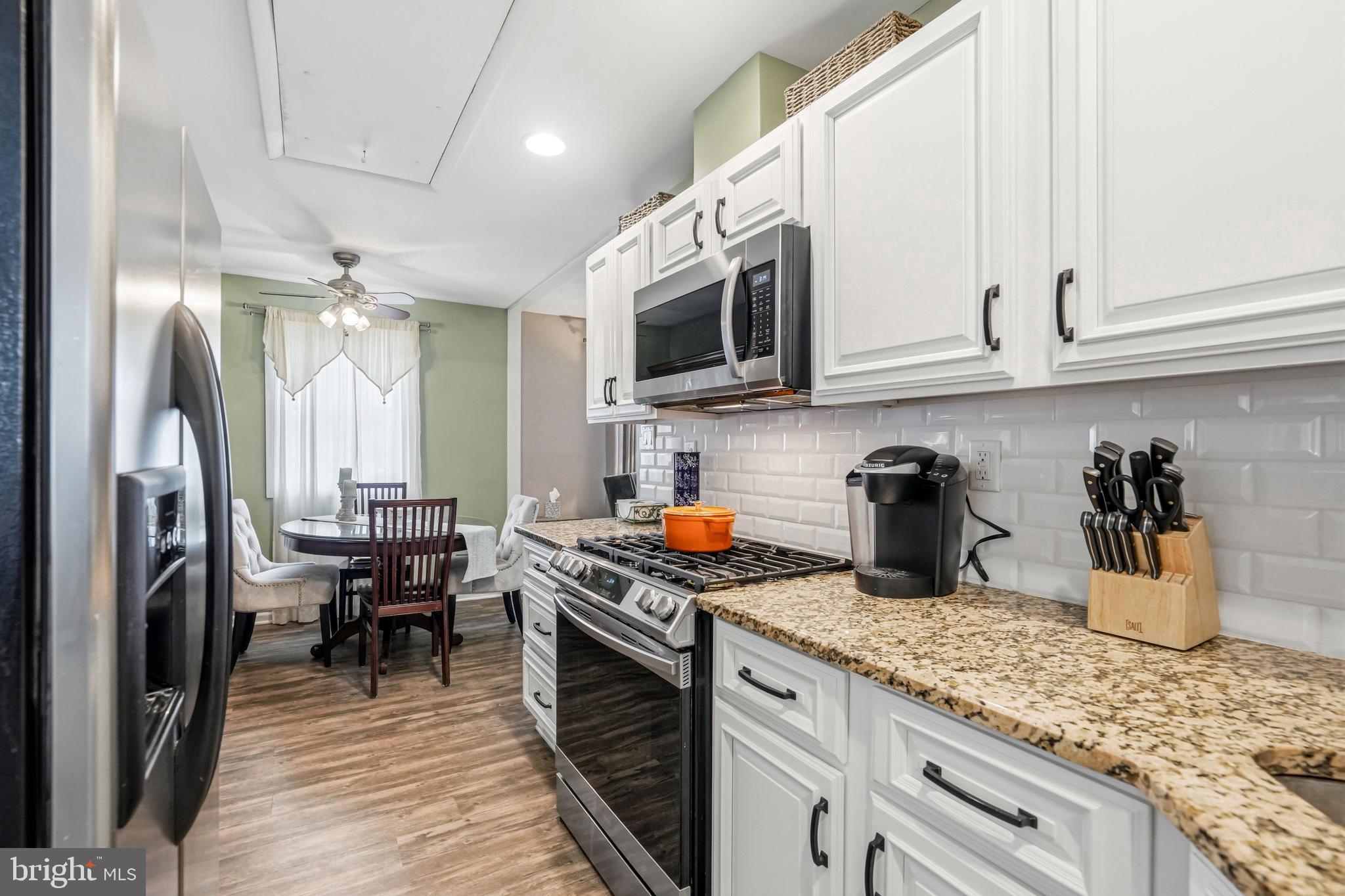 6 Woodbine Avenue Maple Shade, NJ 08052 - Photo 12 of 35 a kitchen with stainless steel appliances granite countertop a stove top oven a sink a dining table and chairs