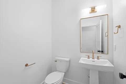 a bathroom with a bathtub shower sink vanity mirror and toilet