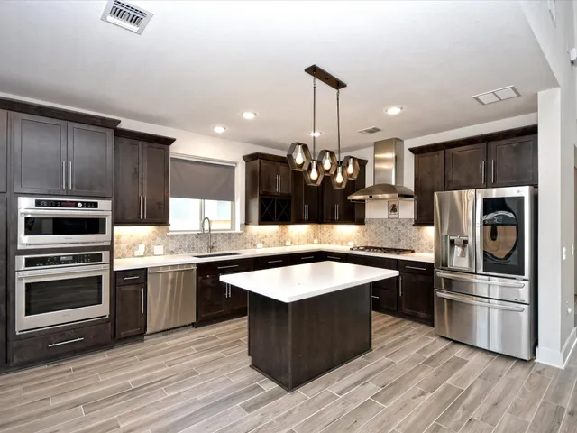 a kitchen with granite countertop a sink and stainless steel appliances