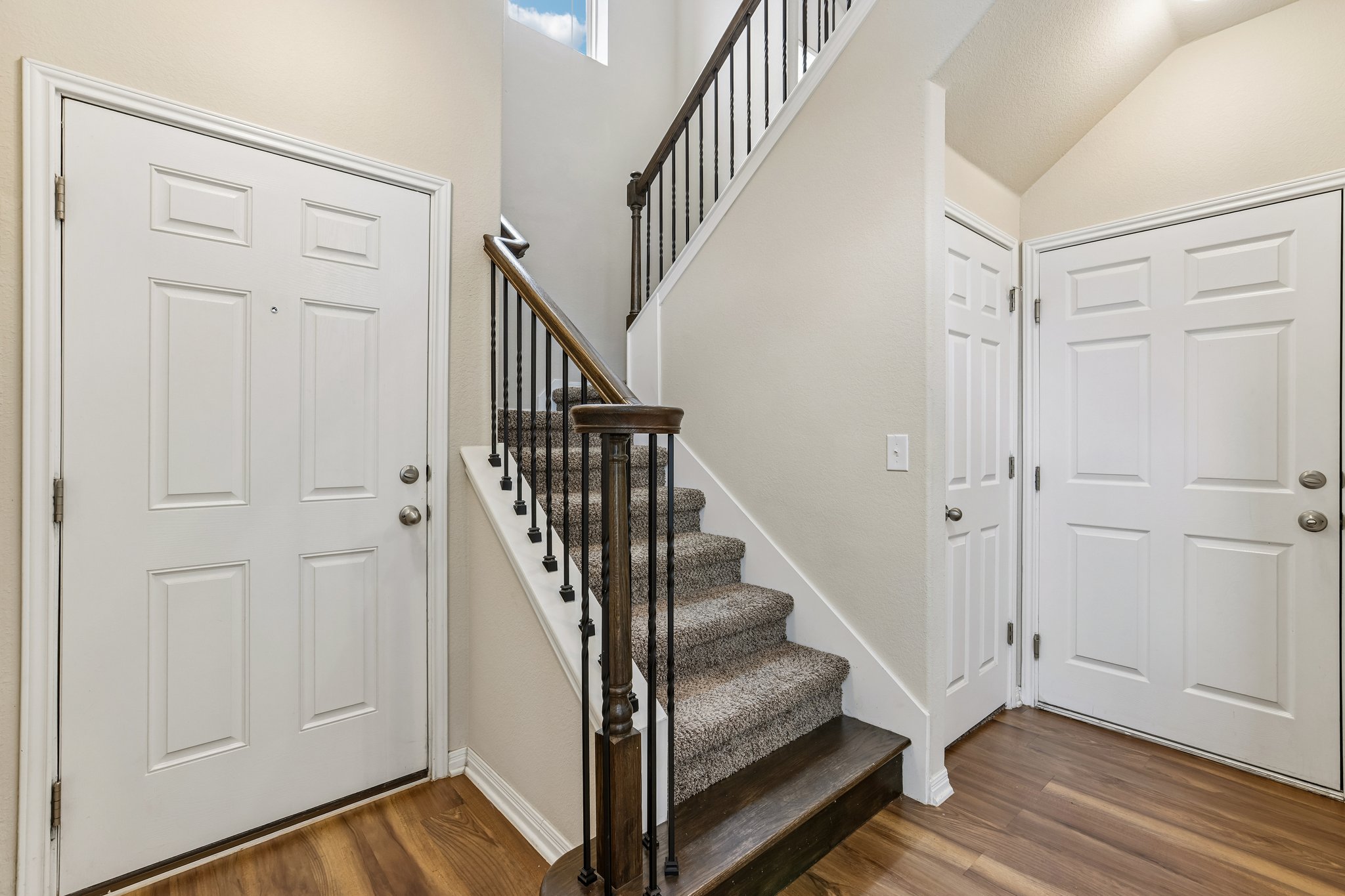808 Totis Road Austin, TX 78748 - Photo 19 of 40 Grand entryway featuring a staircase with carpeted treads and dark wood-finish risers