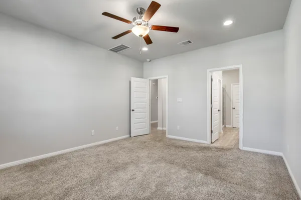 an empty room with closet and a ceiling fan