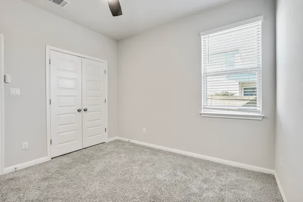 an empty room with windows and closet