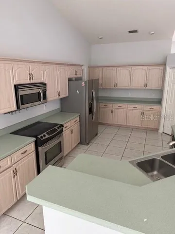a kitchen with kitchen island a sink stove and refrigerator