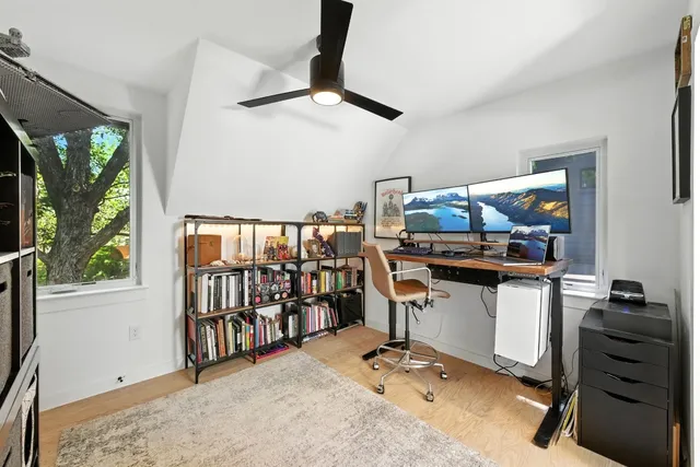 a view of a workspace with furniture and a window