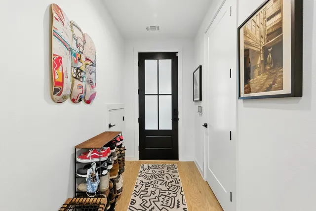 a hallway with painting on the wall and a window