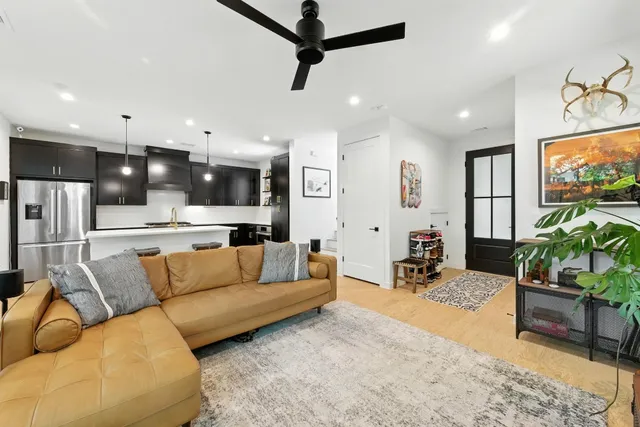 a living room with furniture and kitchen view