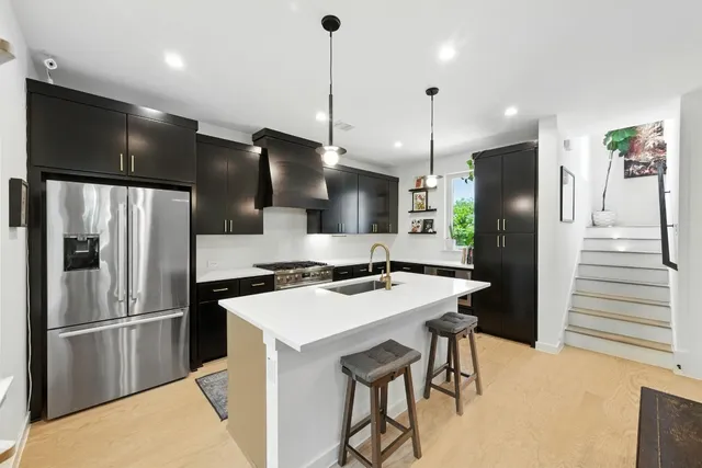 a kitchen with stainless steel appliances kitchen island a refrigerator and a stove top oven