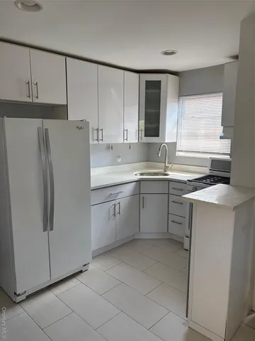 a kitchen with a refrigerator sink and cabinets
