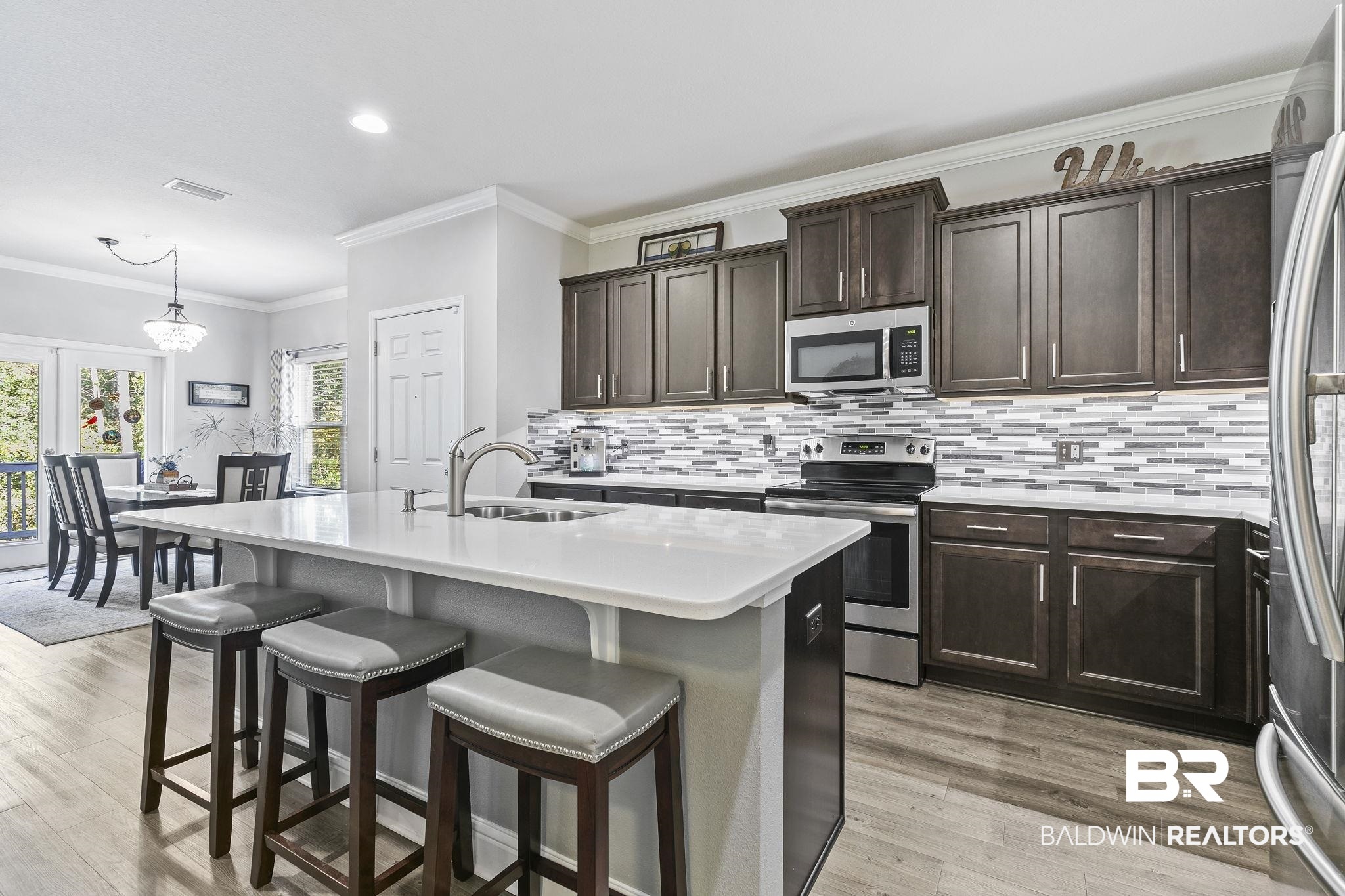 6867 Spaniel Drive, Unit B Daphne, AL 36527 - Photo 10 of 36 Kitchen with appliances with stainless steel finishes, ornamental molding, a kitchen island with sink, sink, and light hardwood / wood-style flooring
