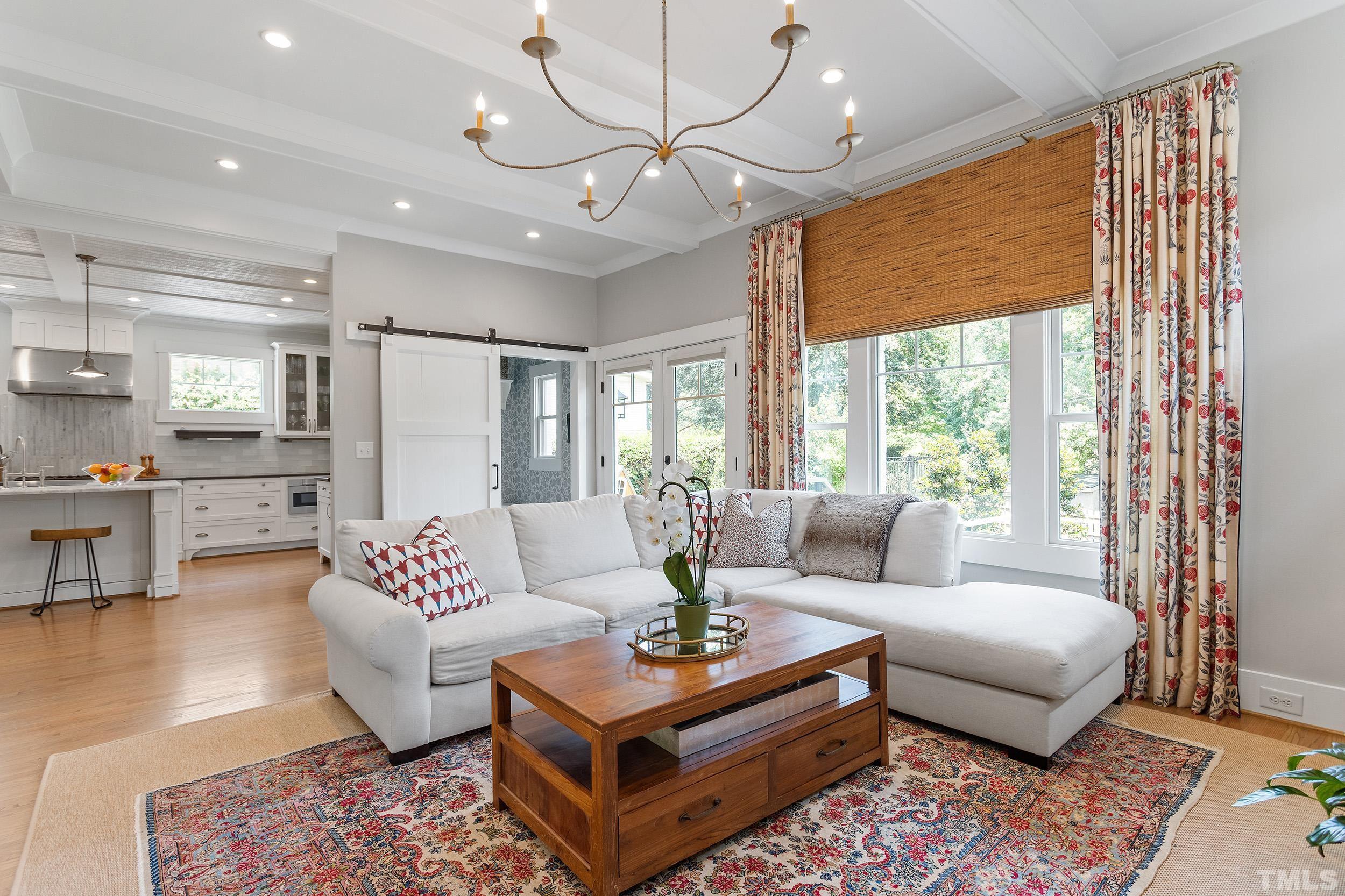 2511 Beechridge Road Raleigh, NC 27608 - Photo 23 of 45 a living room with furniture a dining table and a chandelier