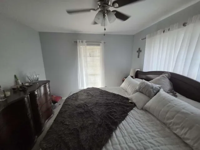 a bedroom with a bed and ceiling fan
