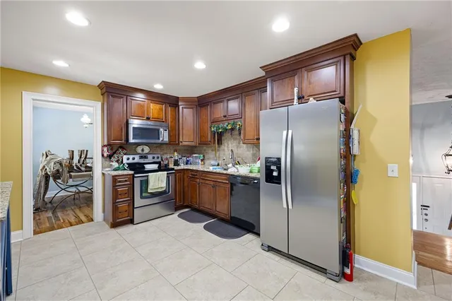 a kitchen with granite countertop a refrigerator and a stove top oven