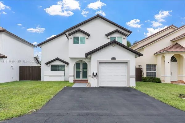 a front view of house with yard and garage