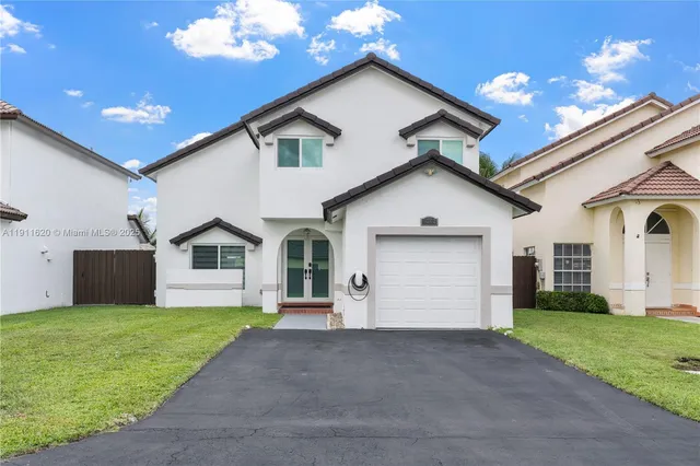 a front view of house with yard and garage