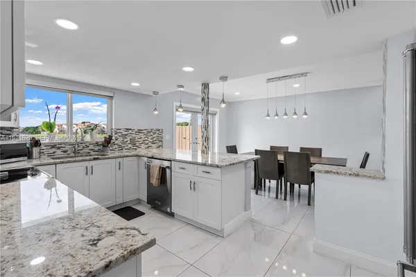 a kitchen with white cabinets and white appliances