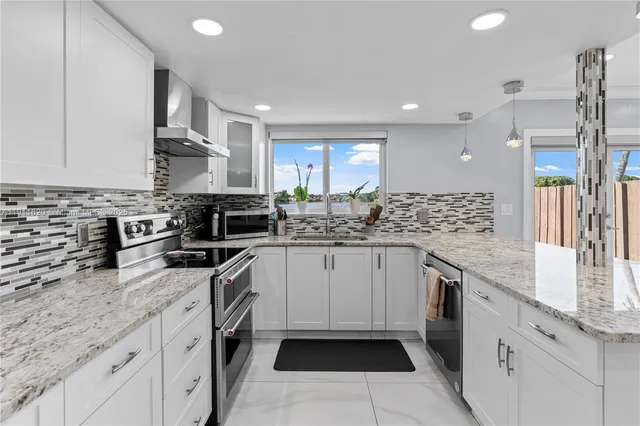 a kitchen with stainless steel appliances granite countertop a sink stove and refrigerator