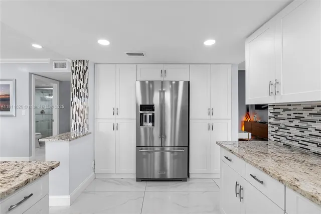 a kitchen with stainless steel appliances granite countertop a refrigerator and a stove