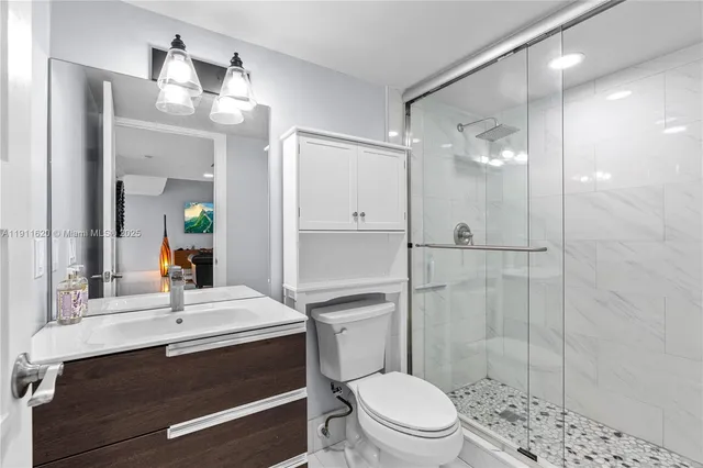 a bathroom with a sink a toilet a mirror and shower