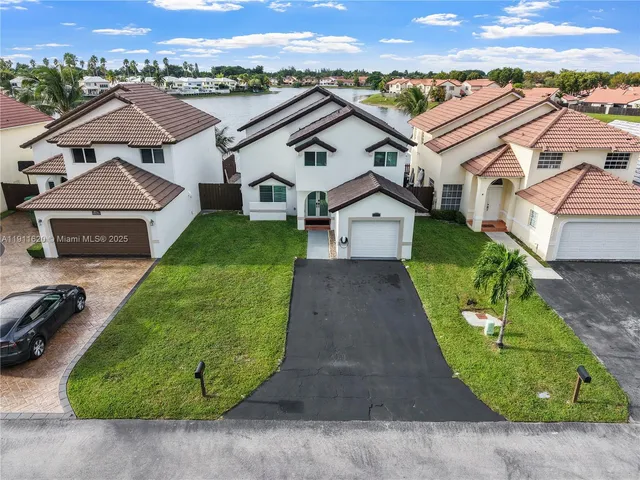 an aerial view of a house with a garden and trees