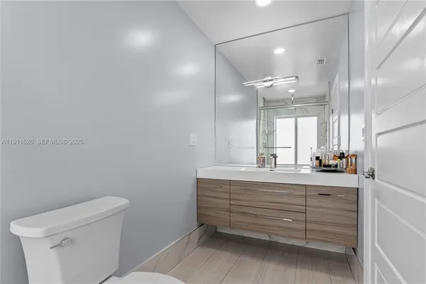 a bathroom with a sink a toilet and a mirror