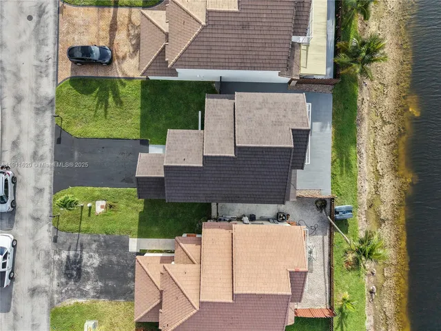 an aerial view of a city with lots of residential buildings ocean and mountain view in back
