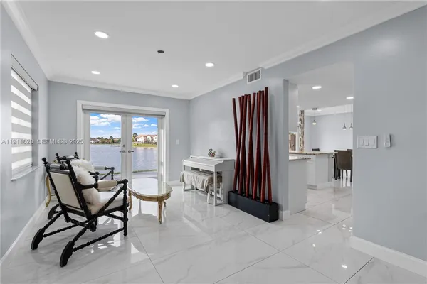 a living room with furniture a large window and stainless steel appliances