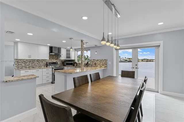 a kitchen with a dining table chairs stainless steel appliances and cabinets