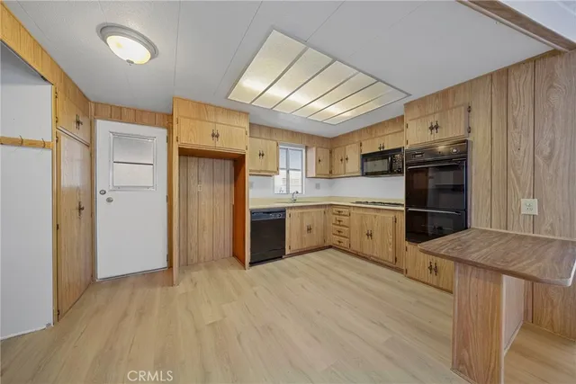 a kitchen with stainless steel appliances white cabinets and wooden floors