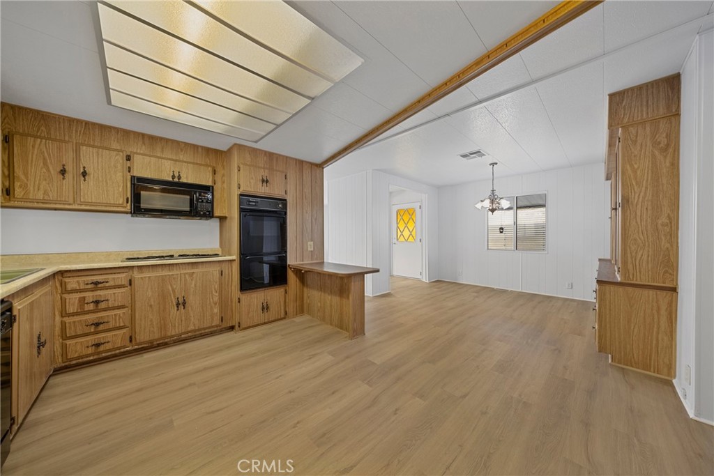 950 California Street, Unit 82 Calimesa, CA 92320 - Photo 28 of 49 a kitchen with stainless steel appliances white cabinets and wooden floors