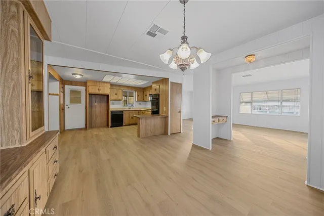 wooden floor in an empty room with a kitchen