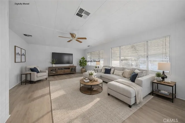 a living room with furniture a flat screen tv and a large window