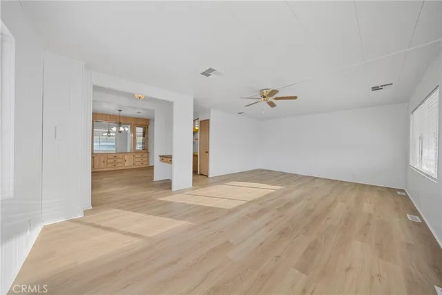 a view of a livingroom with wooden floor and kitchen space