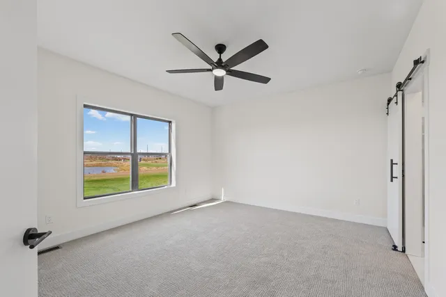 an empty room with windows and fan