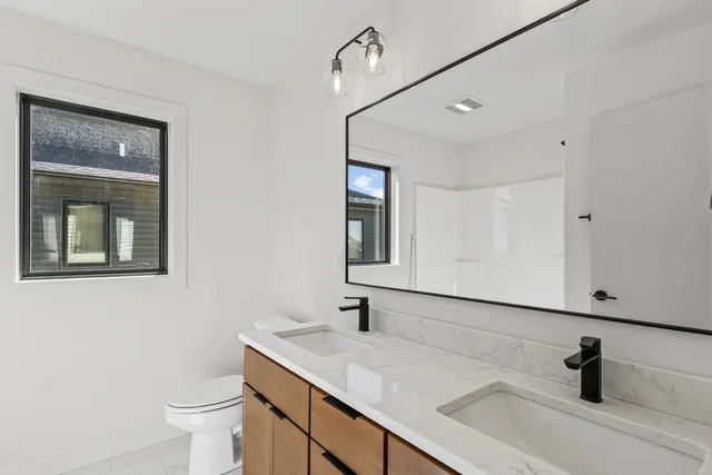 an empty room with windows and ceiling fan