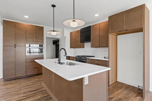 a kitchen with a sink a counter top space stainless steel appliances and cabinets