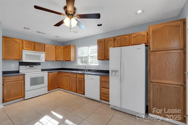 a kitchen with granite countertop stainless steel appliances a refrigerator cabinets and a sink