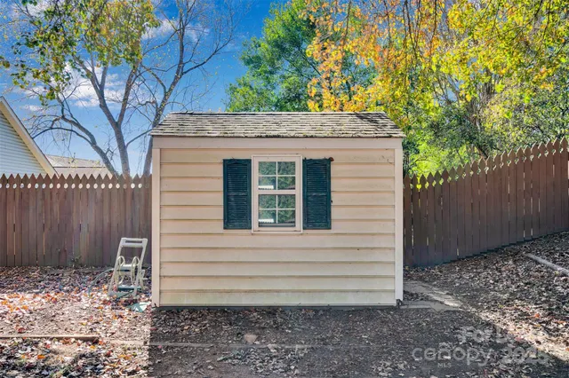 a view of house with backyard and wooden fence