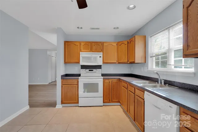 a kitchen with stainless steel appliances granite countertop a sink and a stove