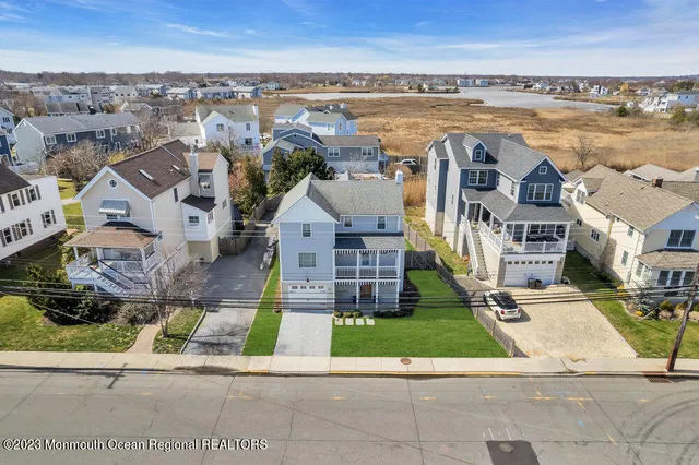 an aerial view of residential houses with outdoor space and ocean view