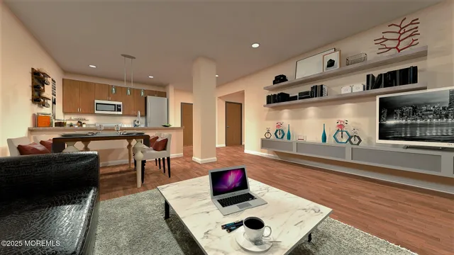 a living room with stainless steel appliances kitchen island granite countertop furniture and a wooden floor